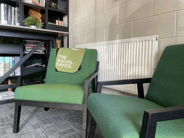 Tow green lounge chairs with black frame for informal meeting