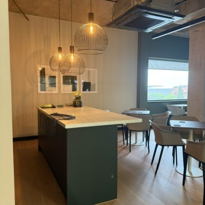 looking into the kitchen with island pendant lighting and tables and chairs for dining