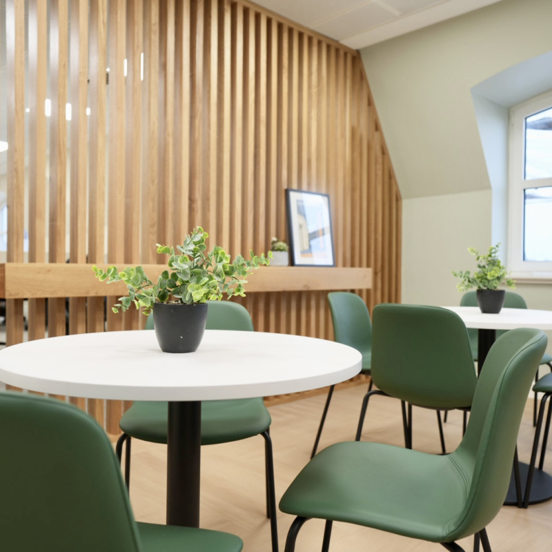 kitchen breakout space with tables and chairs and bespoke joinery wall