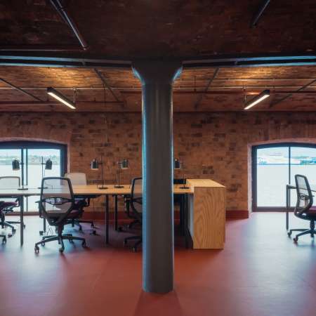 open plan office showing desks and exposed brickwork including iron columns