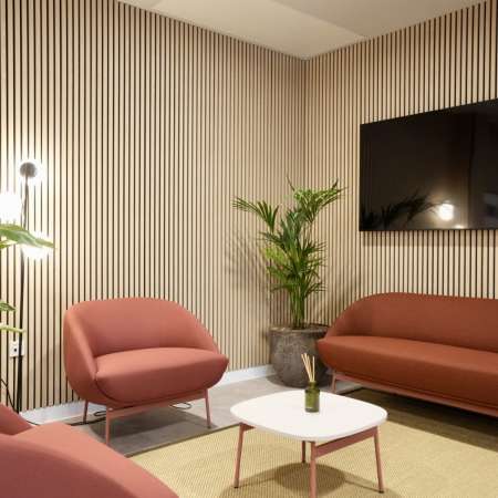 reception seating with TV and wooden slatted wall and new flooring